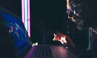 Free photo a man analyzing stock market charts financial data on an electronic board