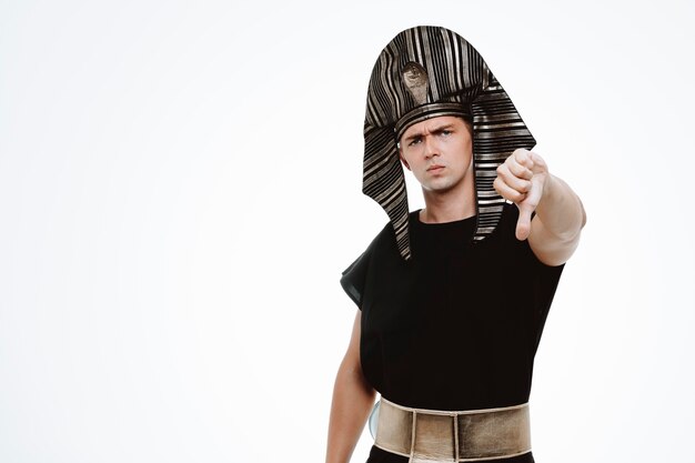 Man in ancient egyptian costume with serious face showing thumb down on white