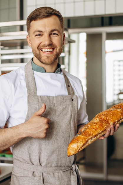 Free Photo man baker with fresh bread at baker house