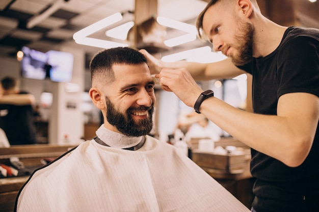 Free photo man at a barbershop salon doing haircut and beard trim