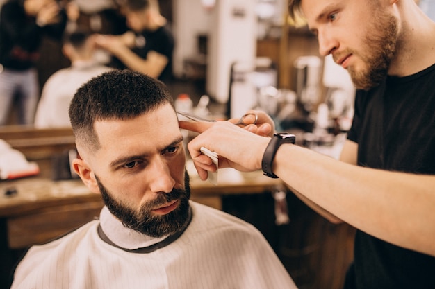 Free photo man at a barbershop salon doing haircut and beard trim