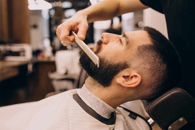 Man at a barbershop salon doing haircut and beard trim