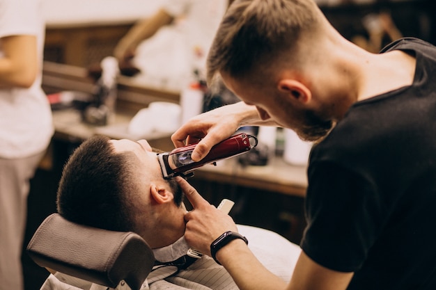 Man at a barbershop salon doing haircut and beard trim