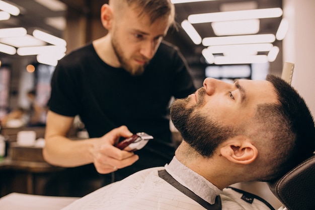 Man at a barbershop salon doing haircut and beard trim