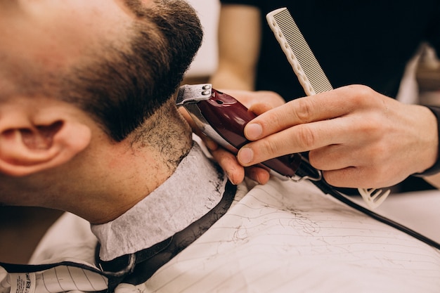 Man at a barbershop salon doing haircut and beard trim