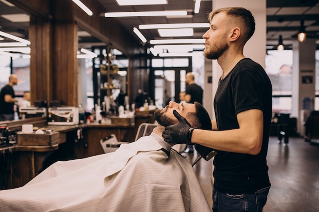 Free photo man at a barbershop salon doing haircut and beard trim