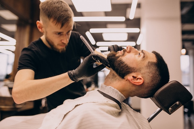 Man at a barbershop salon doing haircut and beard trim