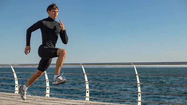 Man at the beach jogging in activewear