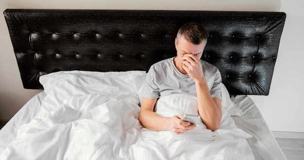 Man in bed using mobile