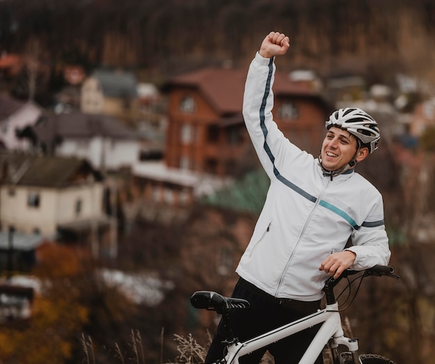 Man being victorious after riding his bike