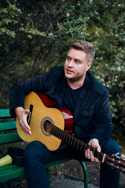 Man on bench playing guitar