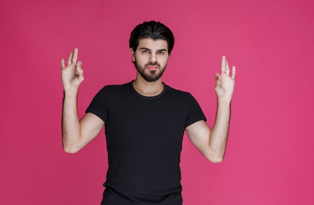 Free photo man in black shirt feels positive about something and enjoys it