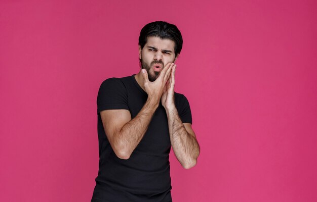 Man in black shirt has toothache