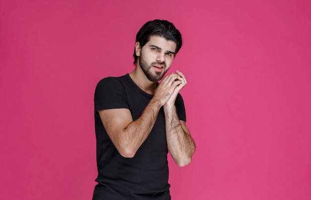 Man in black shirt looks confident and flirtatious