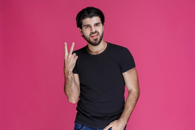 Man in black shirt making peace hand sign