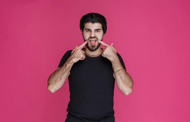 Free Photo man in black shirt making point to a cheerful face