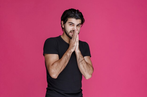 Man in black shirt praying and dreaming about something