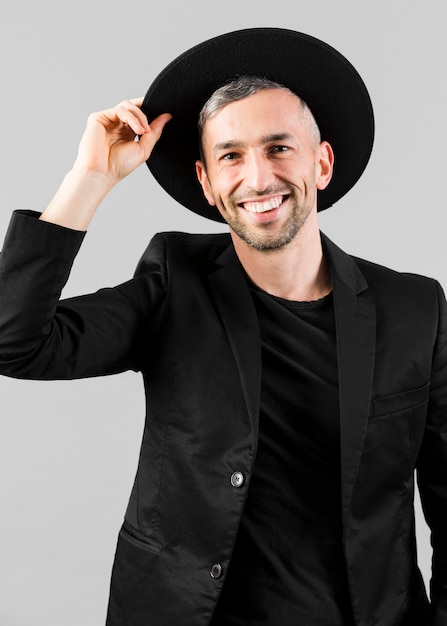 Free photo man in black suit holding his hat