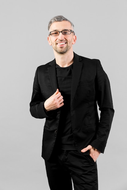 Man in black suit posing indoors