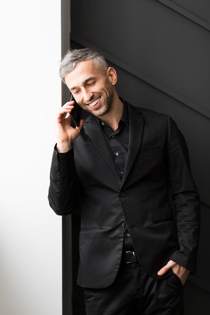 Free photo man in black suit talking at the phone