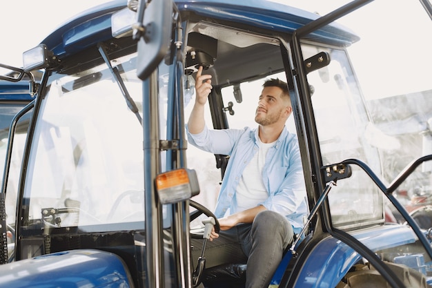 Free photo man in a blue shirt. guy in a tractor. agricultural machinery.