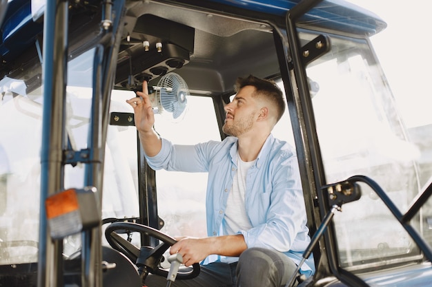 Free photo man in a blue shirt. guy in a tractor. agricultural machinery.