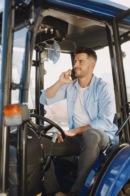 Free Photo man in a blue shirt. guy in a tractor. agricultural machinery.