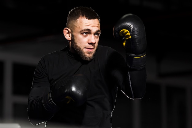 Man boxer posing in protective gloves