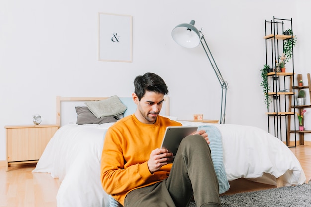 Man browsing tablet on floor