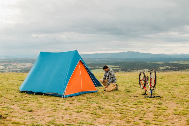 Free Photo man building up tent