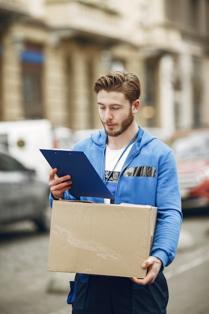 Man by the truck. Guy in a delivery uniform. Man with clipboard.