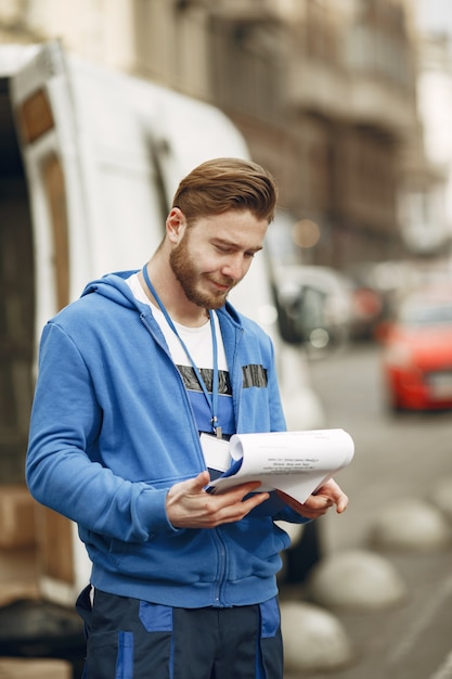 Free Photo man by the truck. guy in a delivery uniform. man with clipboard.