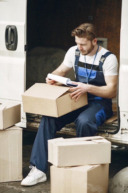 Free photo man by the truck. guy in a delivery uniform. man with clipboard.