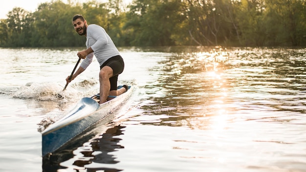 Man in canoe rowing concept