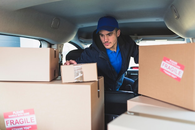 Man in car checking boxes for delivery