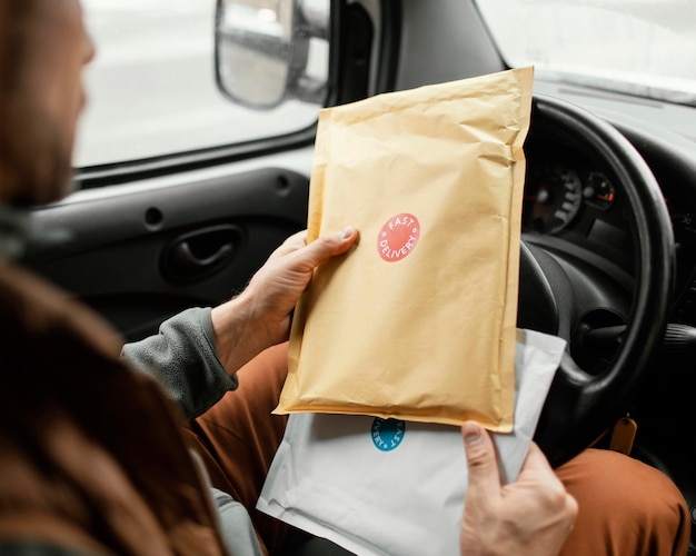 Man in car delivering package close up