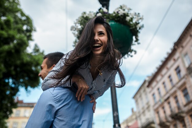 Man carrying laughing girl on back