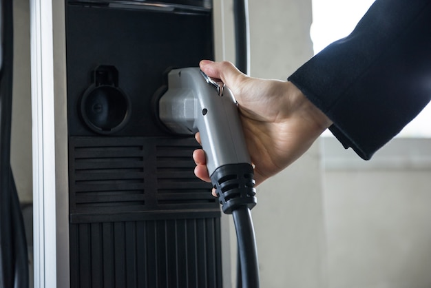 Man charging car at electric vehicle charging station