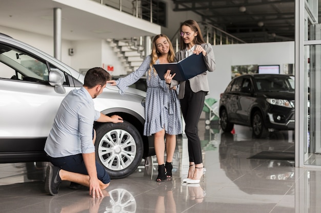 Man checking car tires in a showroom