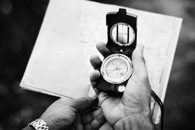 Free photo man checking direction on a compass