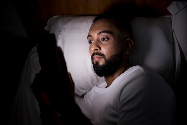 Man checking his phone before sleeping