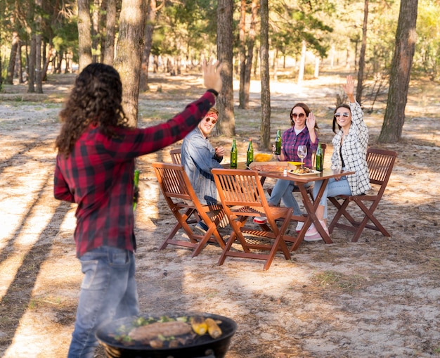 Free Photo man cheering with friends while holding beer and having a barbecue