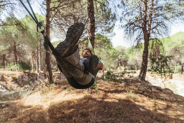 Free photo man chilling in hammock in forest