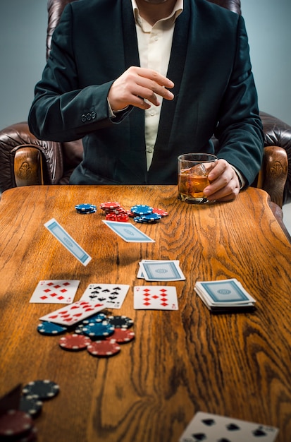 Free photo the man, chips for gamblings, drink and playing cards