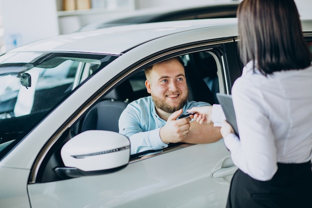 Man choosing a car in a car saloon