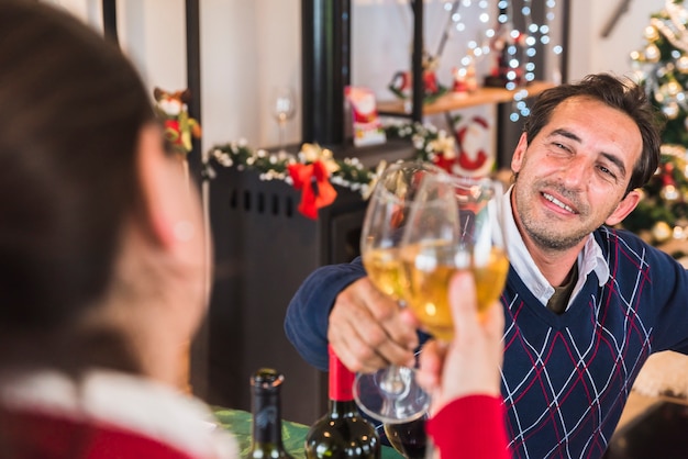 Man clanging glass of wine with woman 