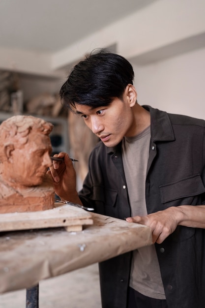 Free photo man clay sculpting side view