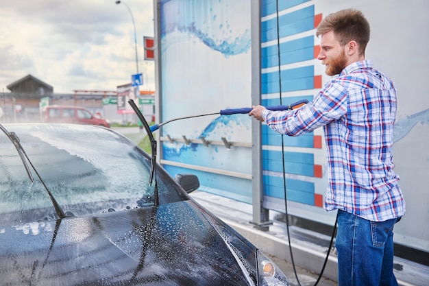 Man cleaning his car in a self service