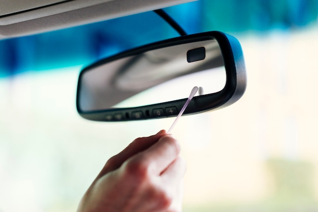 Free Photo man cleaning interior car mirror