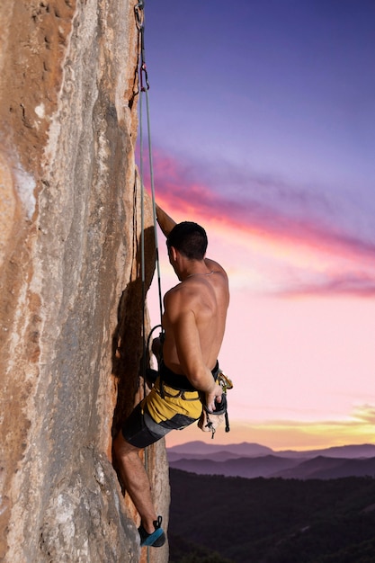 Free Photo man climbing on a mountain with safety equipment